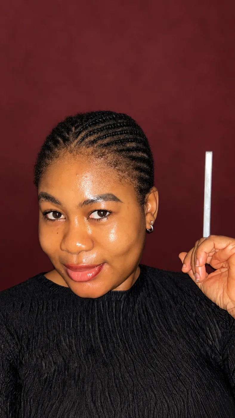 Cynthia holding a serum dropper beside her glowing skin
